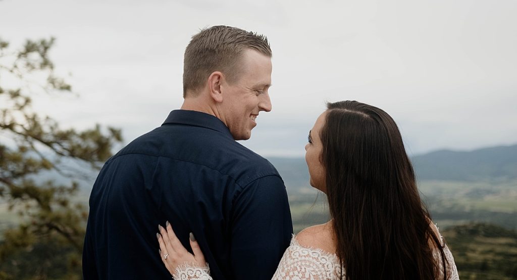 engagement pictures with couple hugging overlooking the mountains