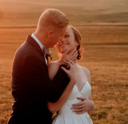 bride and groom kissing during sunset wedding photos