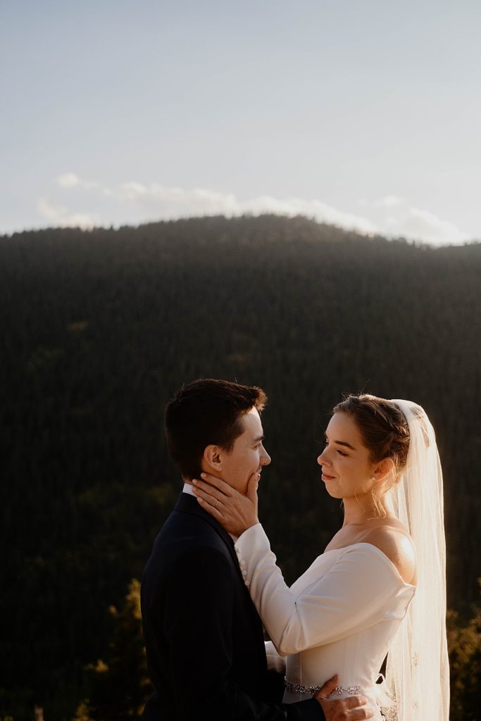 bride and groom standing in front of the colorado mountains