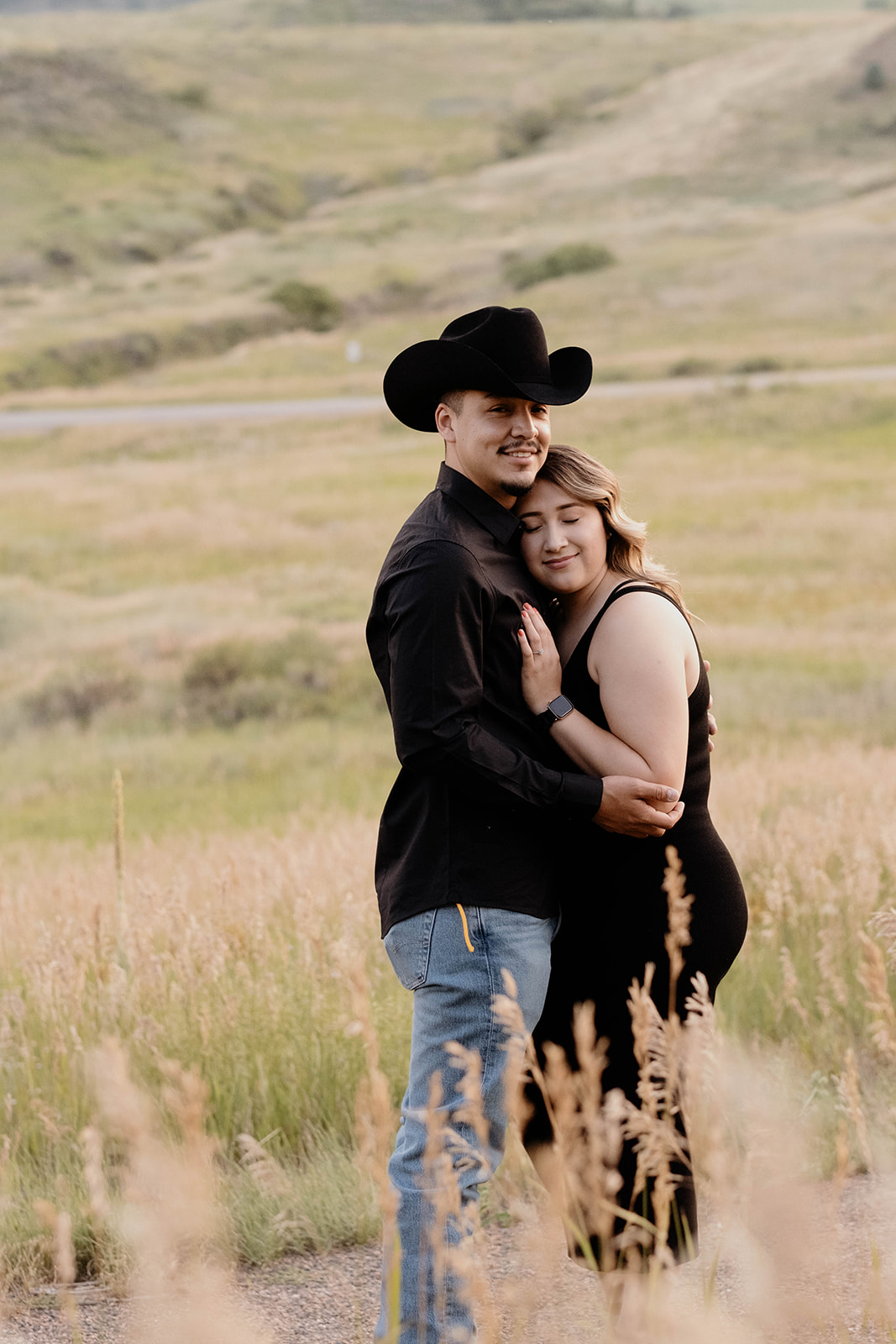 couple hugging in field in colorado during engagement photos