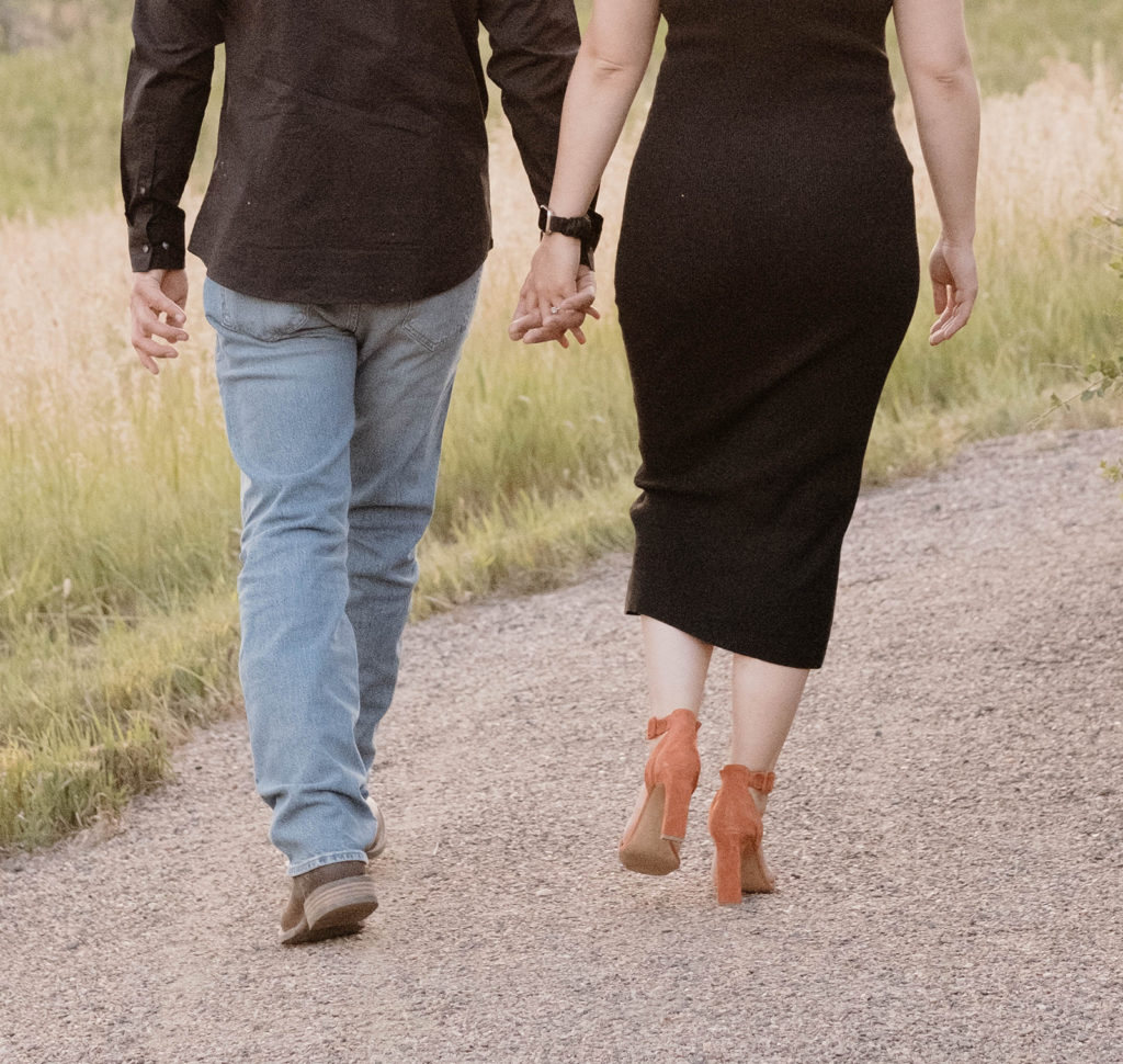 couple holding hands walking at engagement photoshoot