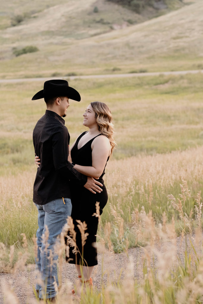 couple hugging in field in colorado during engagement photos