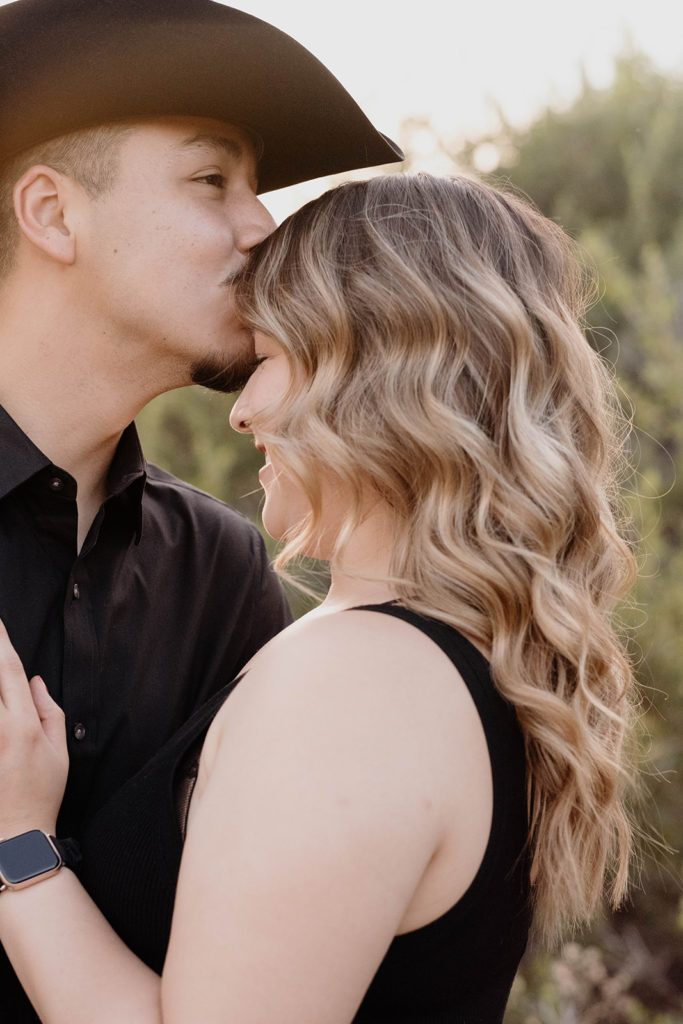 man kissing forehead of soon to be fiance