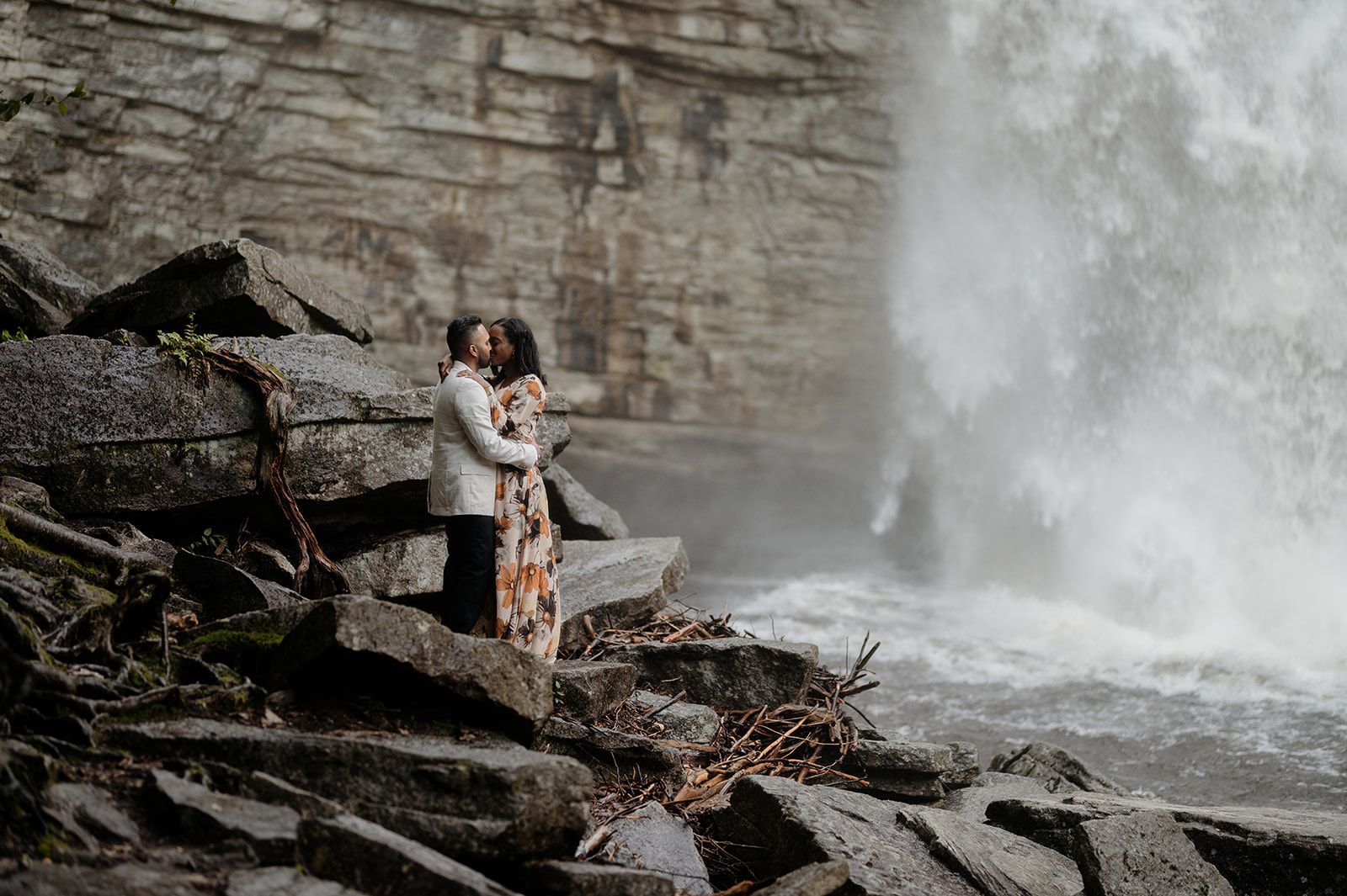 couple hugging at waterfall engagement shoot